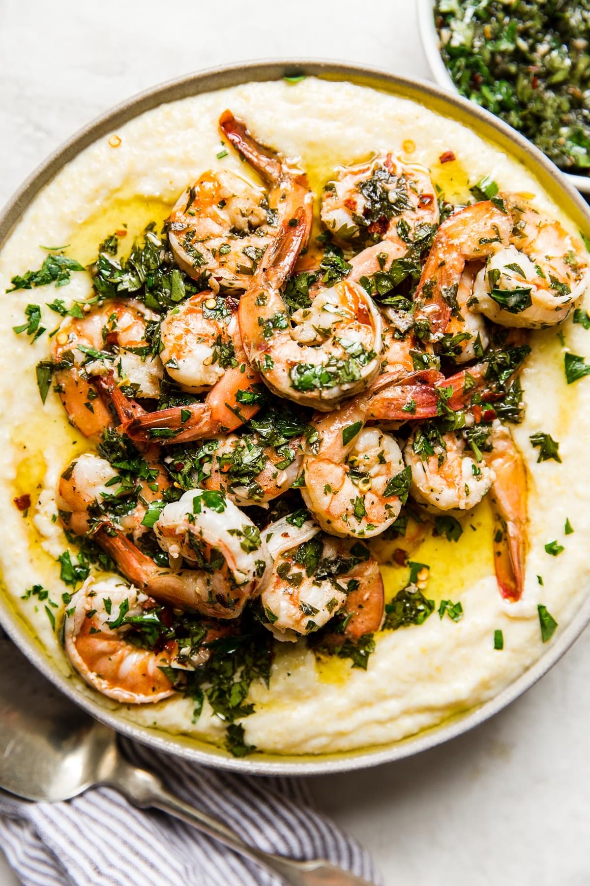 Chimichurri Shrimp With Creamy Polenta in a bowl with a serving spoon