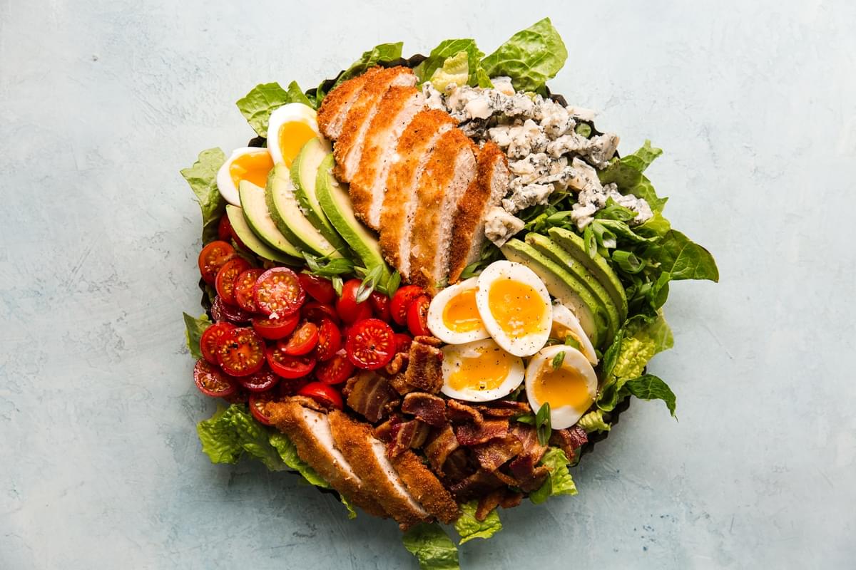 classic cobb salad with crispy breaded chicken on a round platter