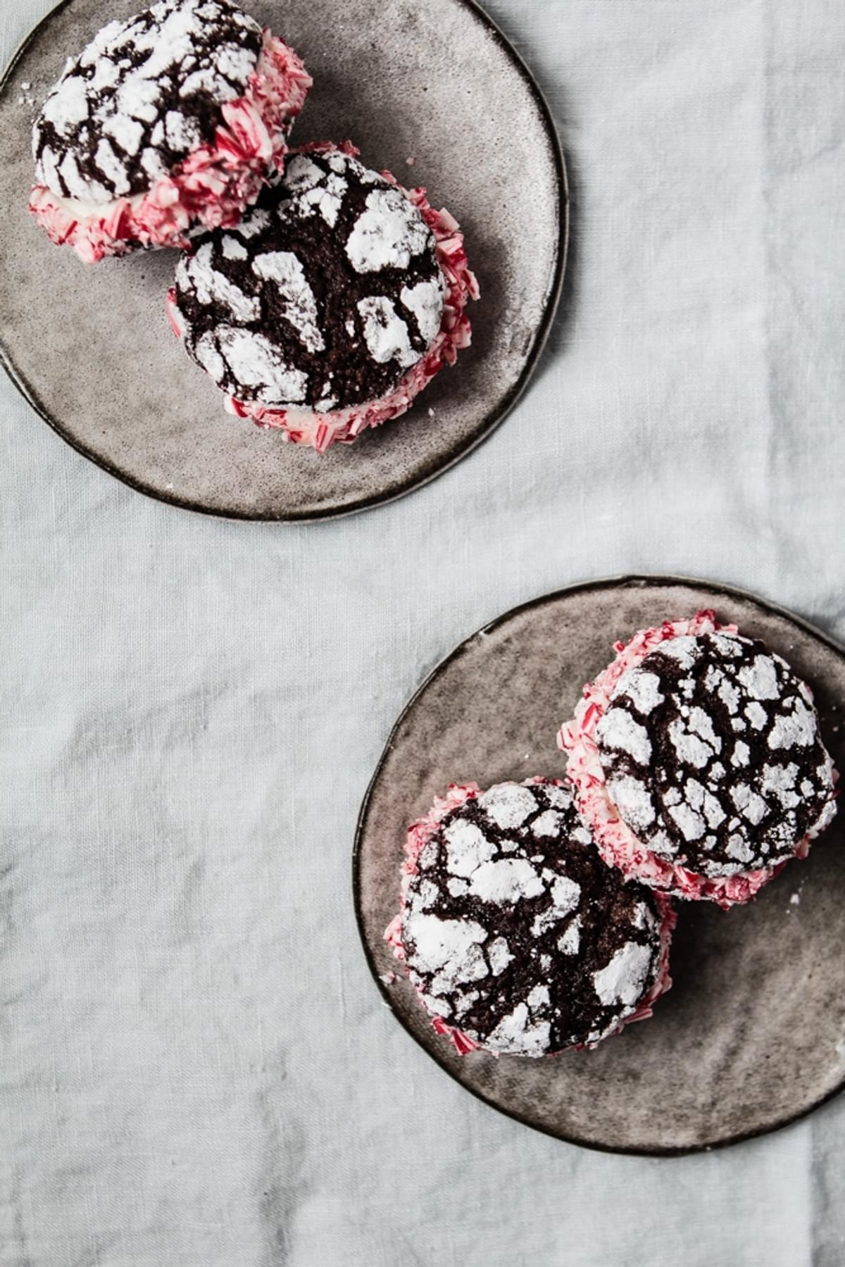 two plates with chocolate Crinkle Cookies With Peppermint Cream with powdered sugar and crushed peppermint candy