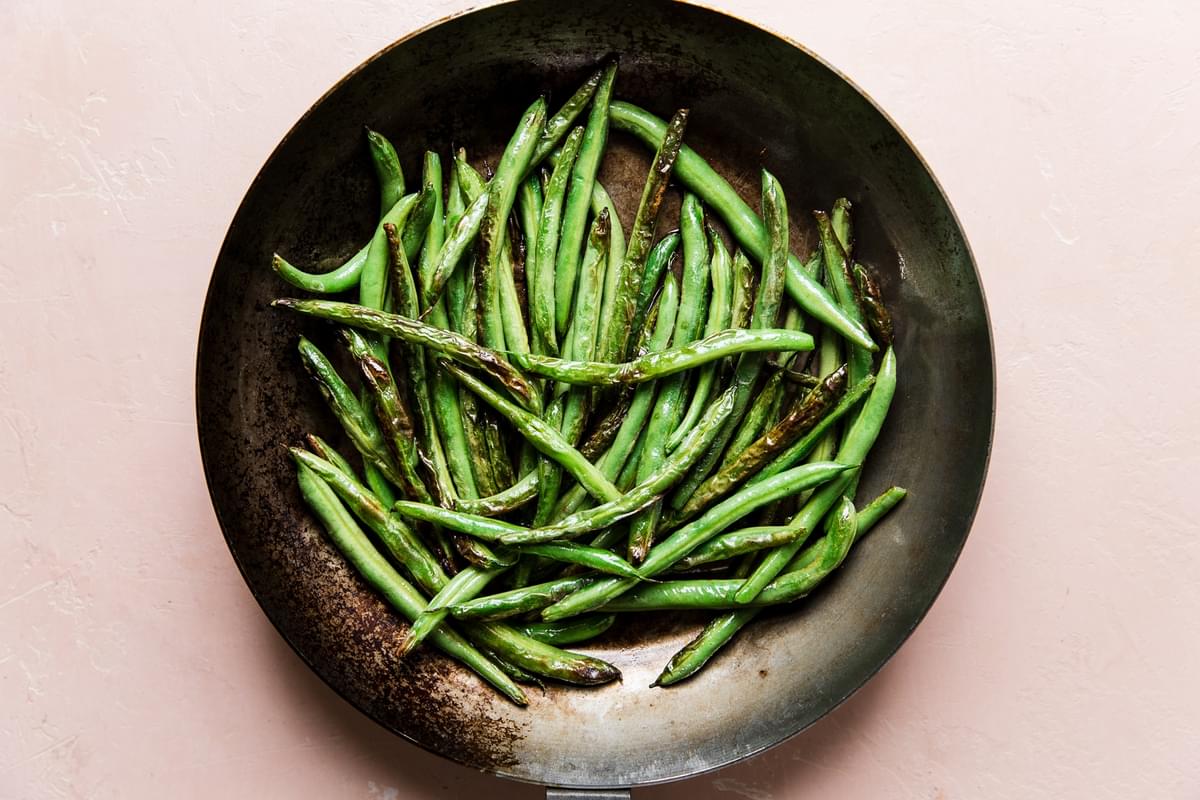 charred green beans in a skillet