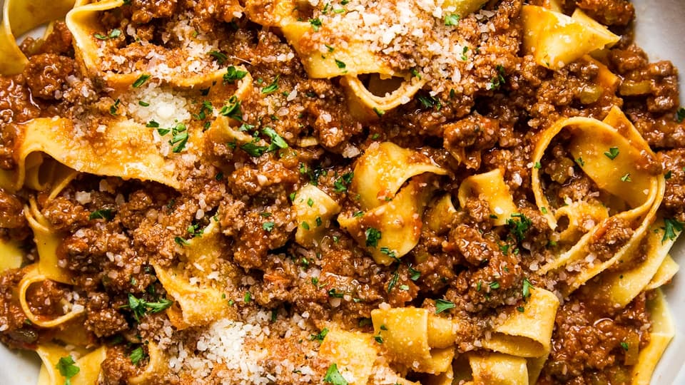 large bowl of homemade bolognese with pasta and fresh parmesan
