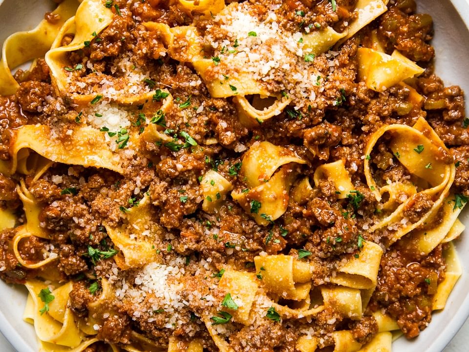 large bowl of homemade bolognese with pasta and fresh parmesan