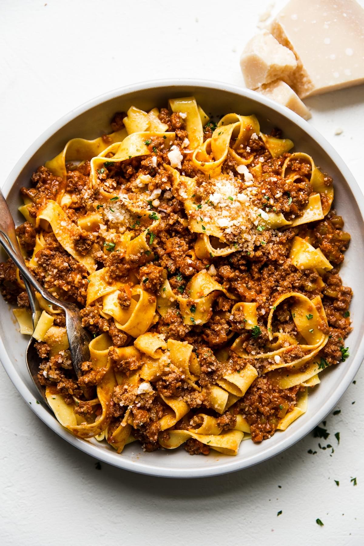 easy homemade bolognese in a large bowl with a spoon and fork