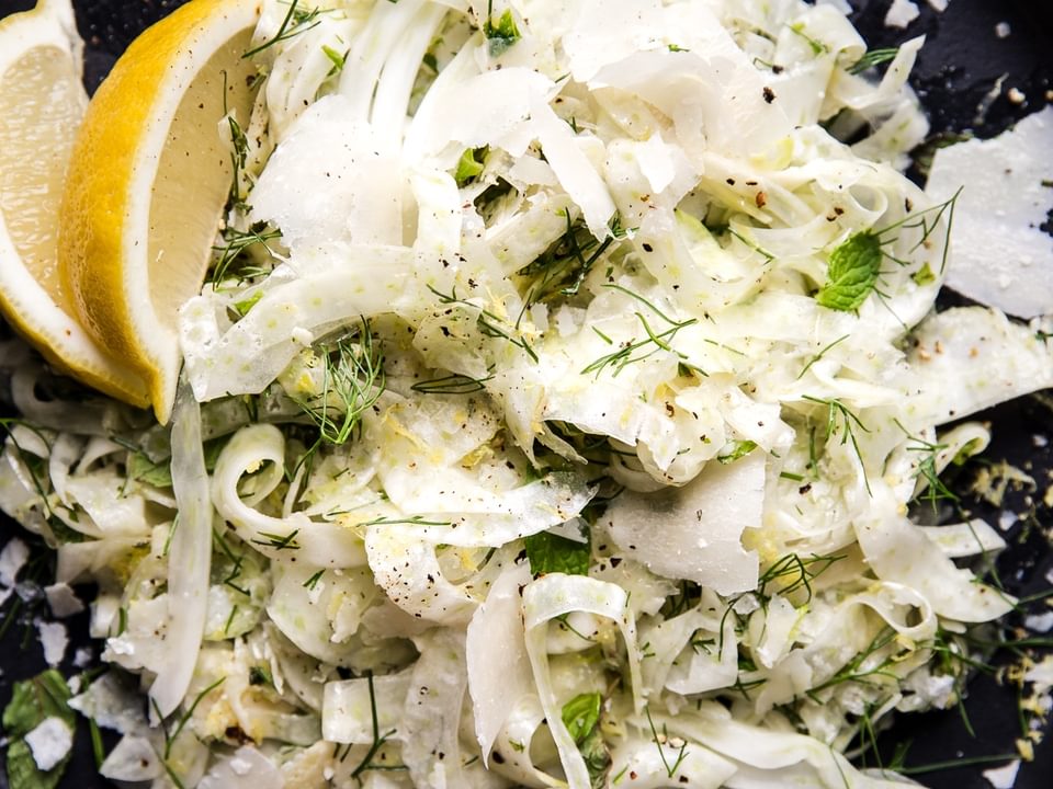 easy shaved fennel salad with parmesan cheese and fresh herbs on a plate