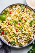 Mexican Street Corn Salad in a large bowl served with chipotle crema