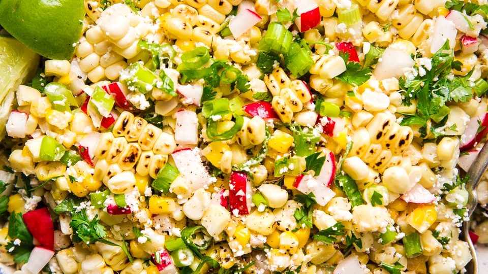 Mexican Street Corn Salad in a large bowl served with chipotle crema