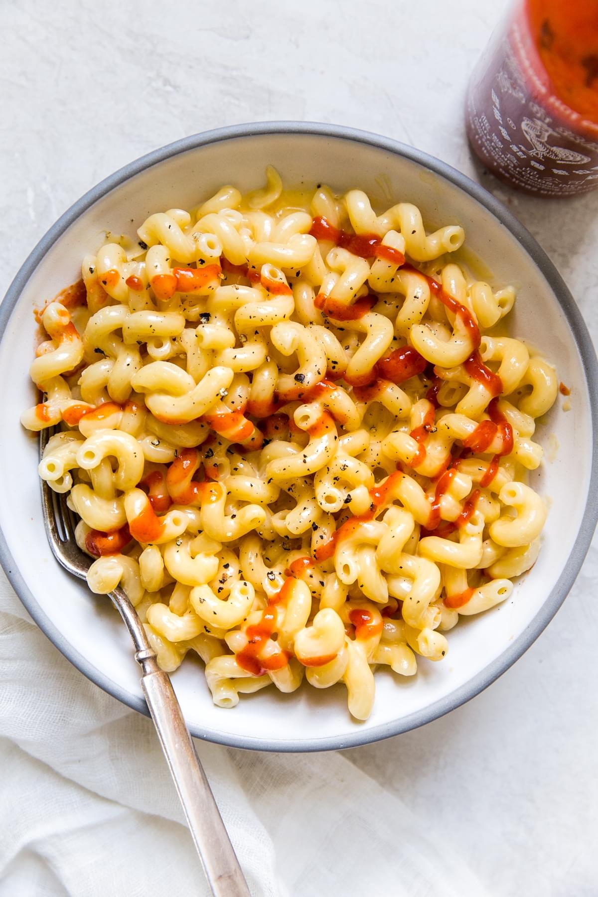 four ingredient stovetop mac and cheese in a bowl topped with Sriracha
