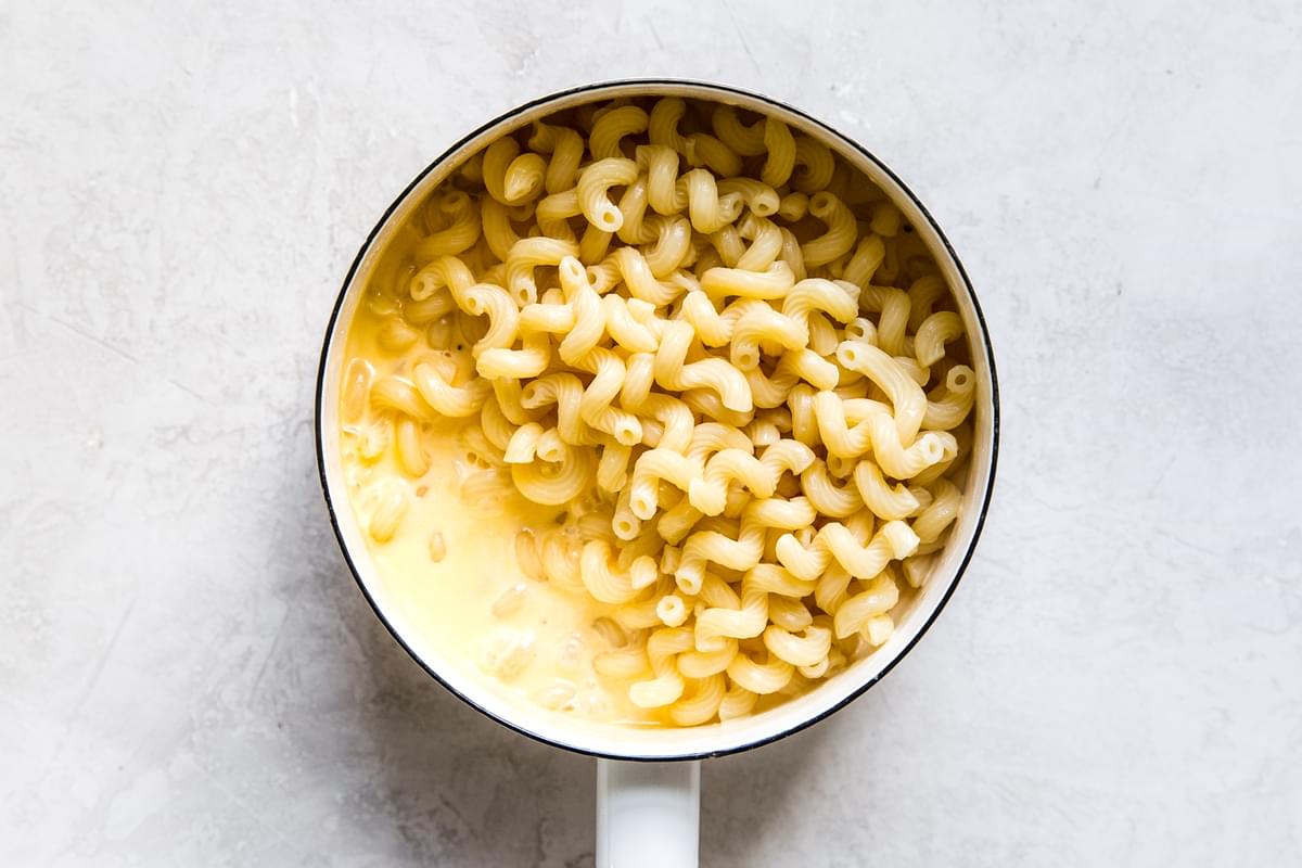 cheese sauce and cooked pasta in a saucepan
