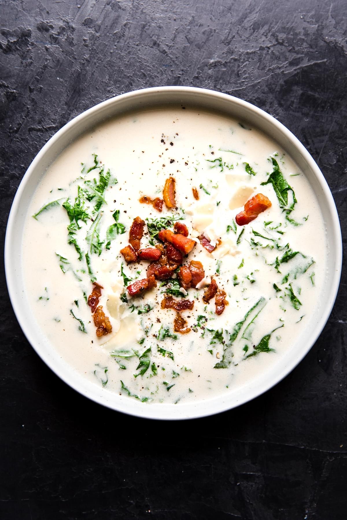 garlic soup in a bowl with kale and crispy pancetta