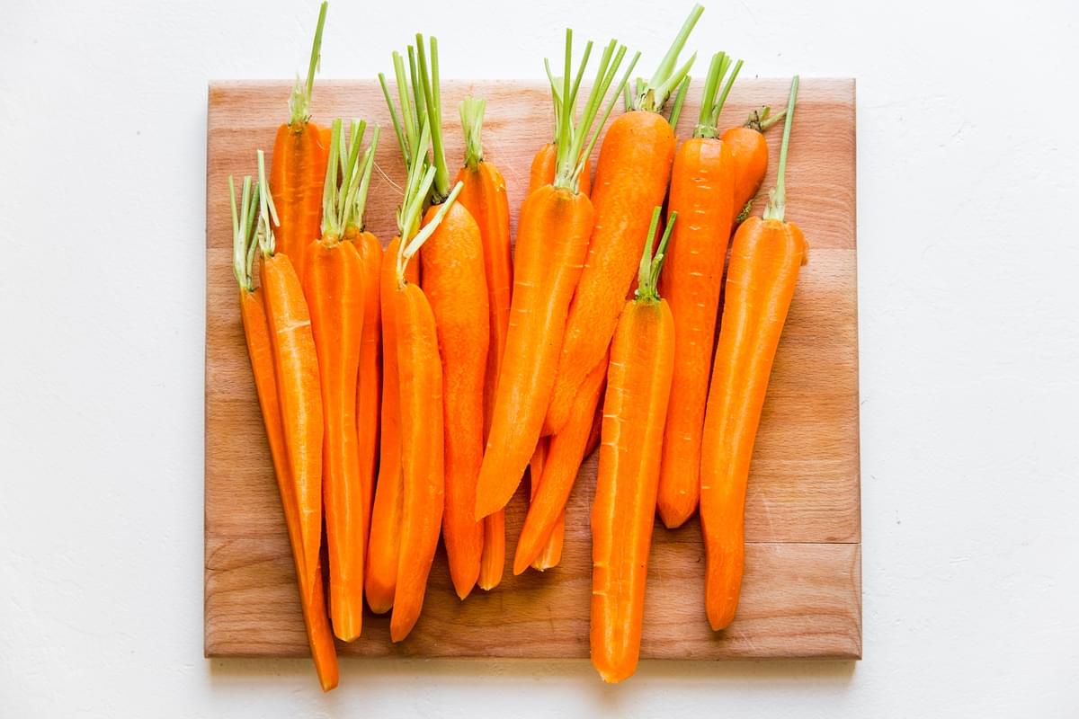 10 carrots halved lengthwise on a cutting board