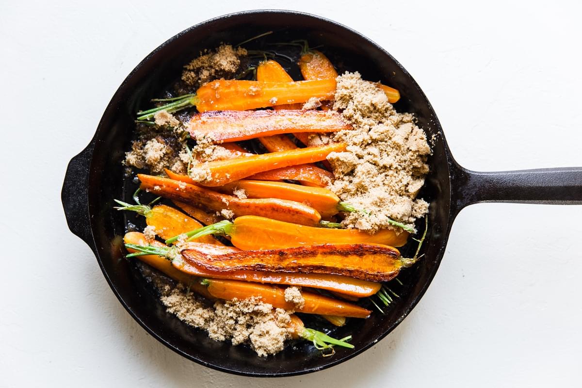 carrots cooked in a cast iron skillet topped with brown sugar