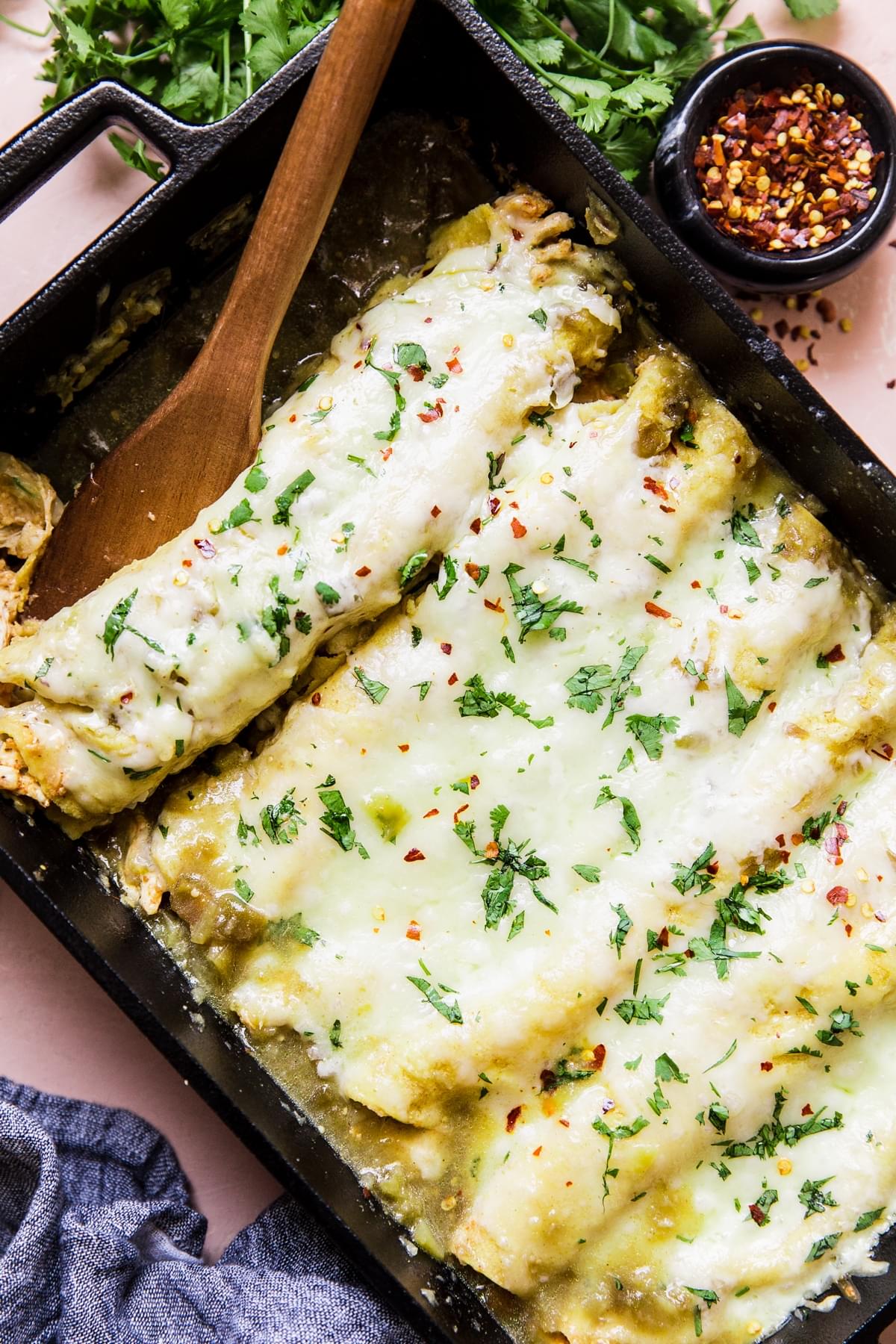 Green Chicken Enchiladas with melted cheese and extra sauce