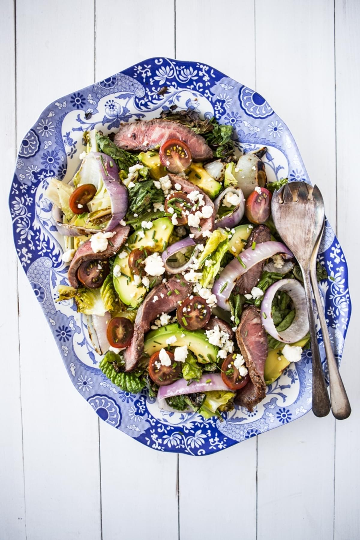 low carb grilled steak salad with grilled onions, lettuce, avocado and a creamy blue cheese dressing