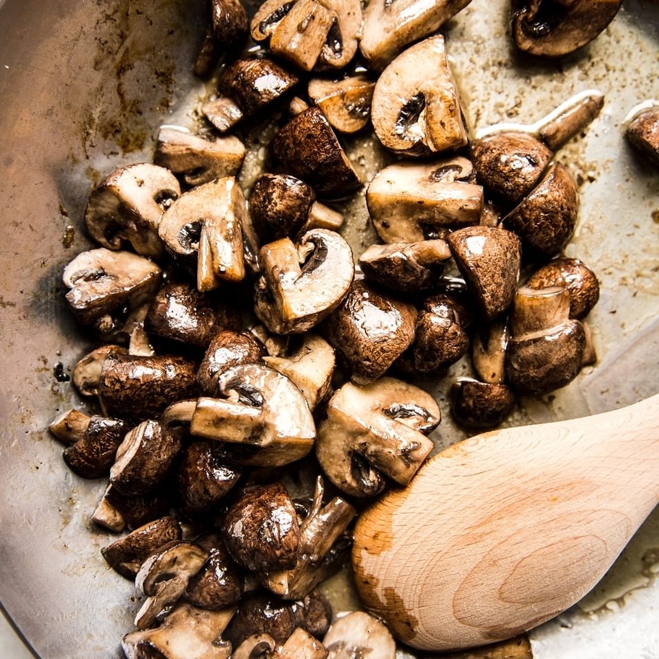 Dry Sauté Mushrooms in a pan with a wooden spoon