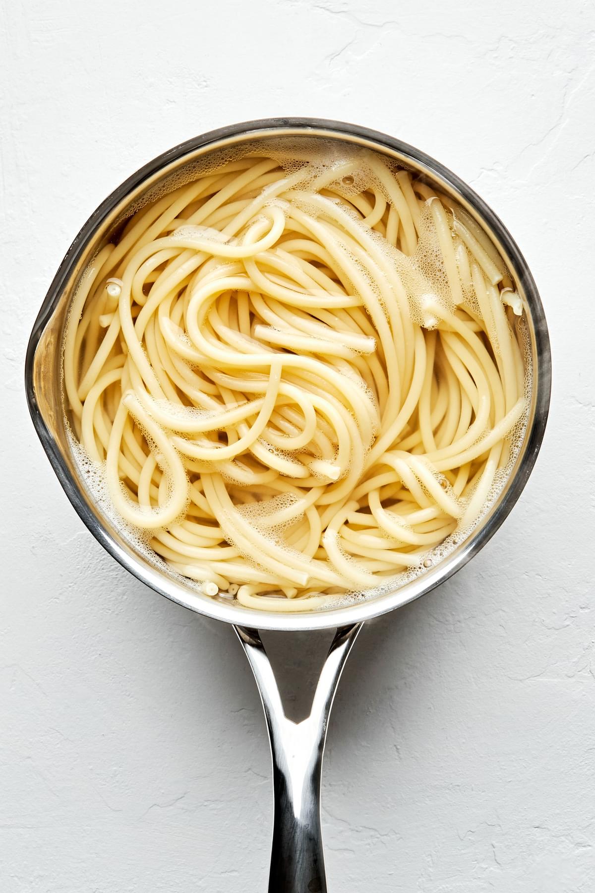 pasta noodles being cooked in salted water