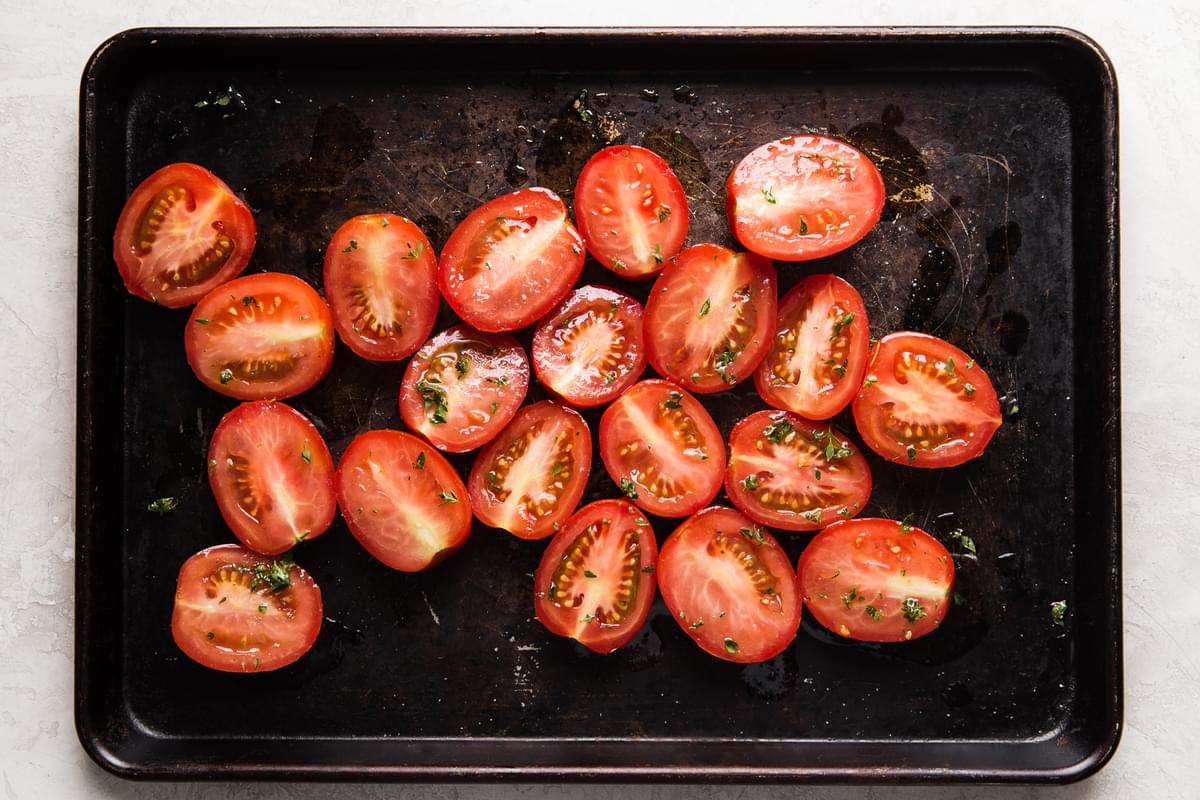halved roma tomatoes on a sheet pan
