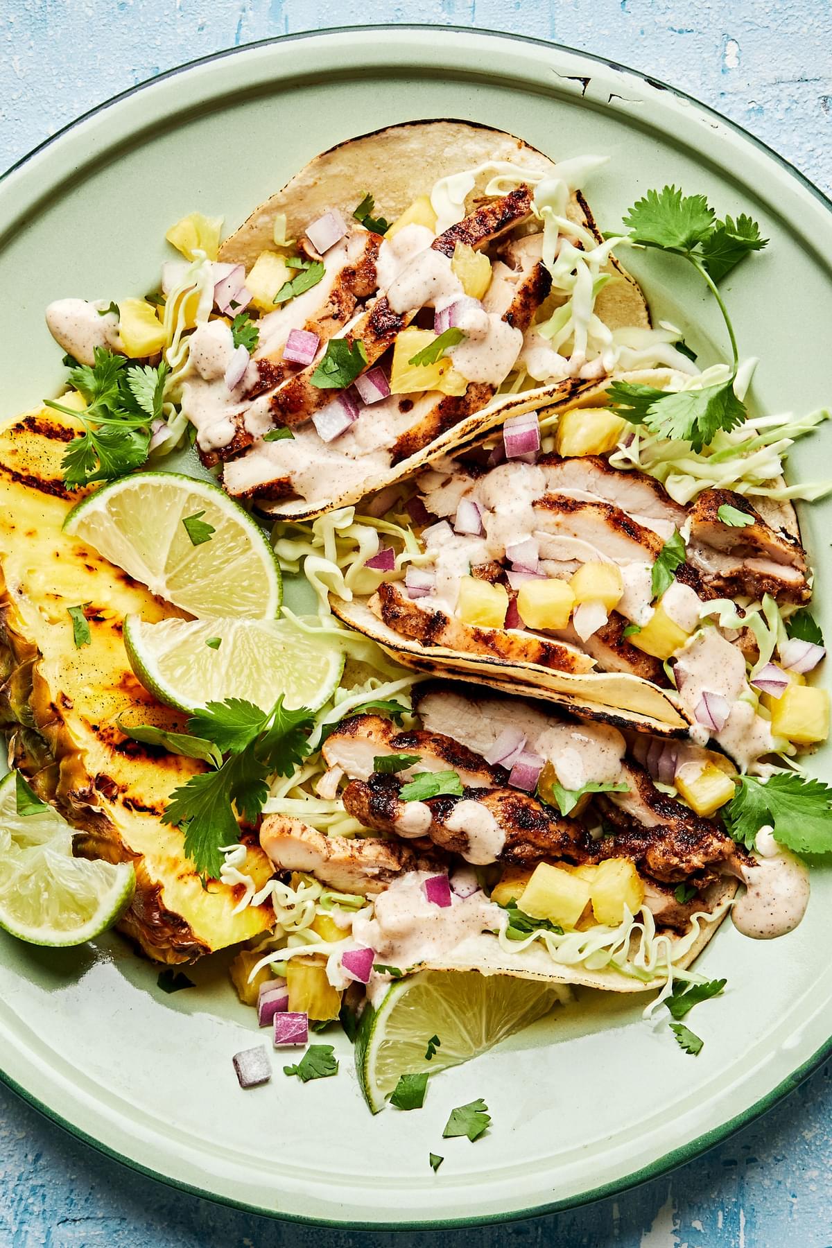 jerk chicken tacos topped with onion, pineapple, cabbage, cilantro and jerk aioli. served with a wedge of grilled pineapple