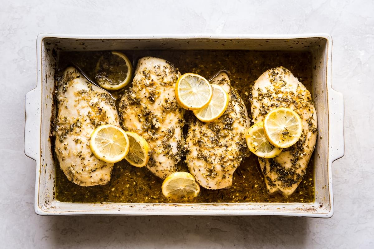 4 Baked lemon chicken breast in a baking dish topped with lemon slices