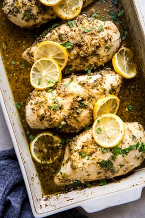4 lemon chicken breasts baked in a baking dish with olive oil, white wine, lemon juice, garlic and spices