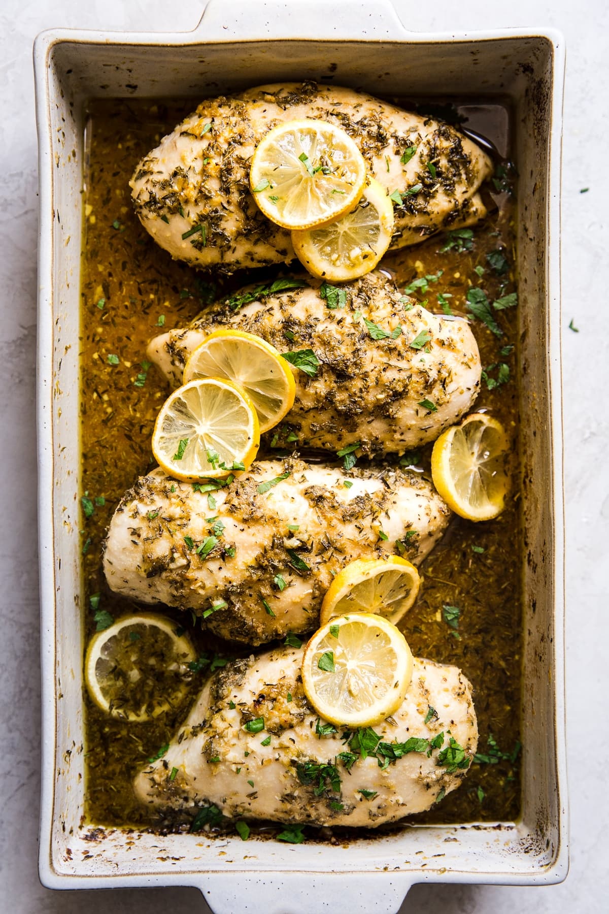 Lemon garlic Chicken breasts baked in a baking dish  topped with