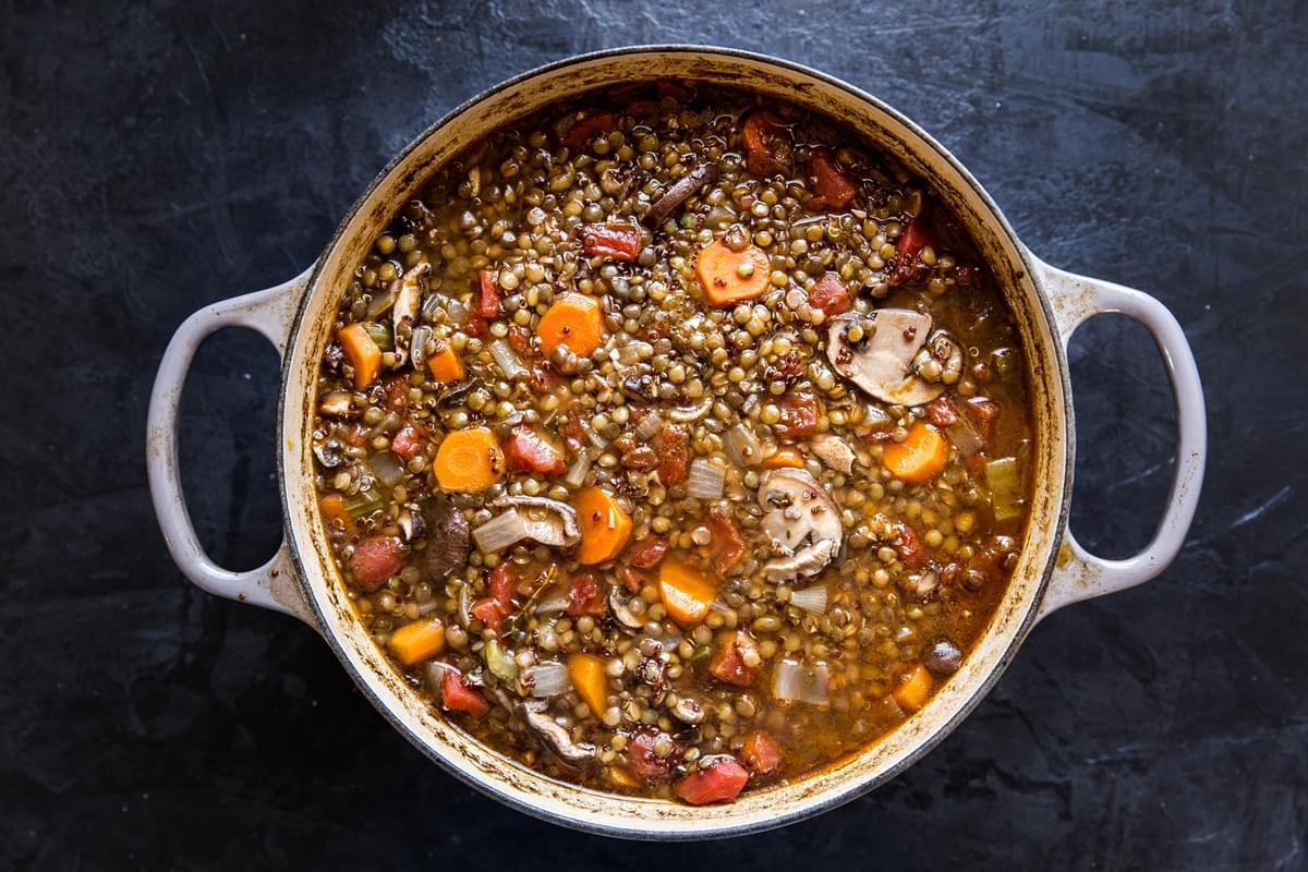 large soup pot with lentil stew with quinoa and mushrooms