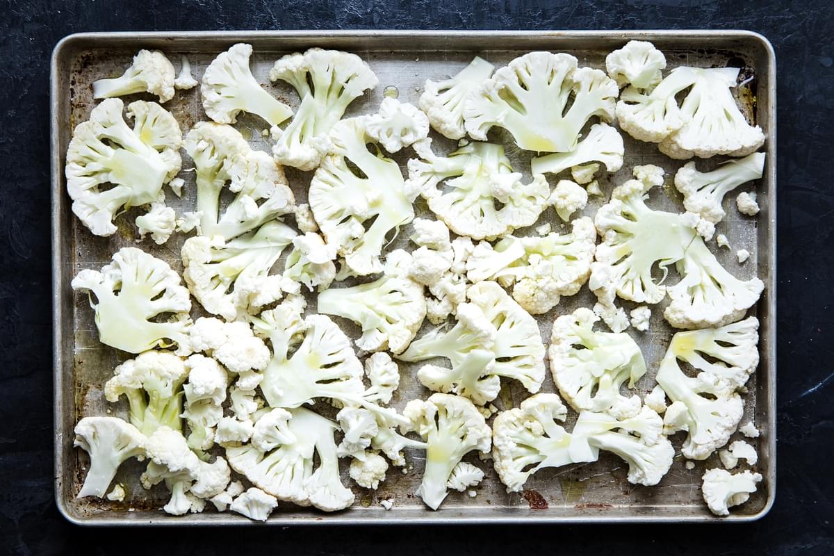 Cauliflower sliced and placed on a baking sheet with olive oil and salt