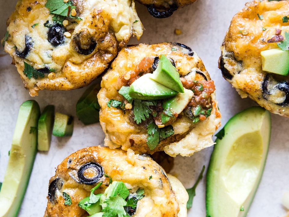 sausage and cheese breakfast egg muffins with avocados  and a bowl of salsa