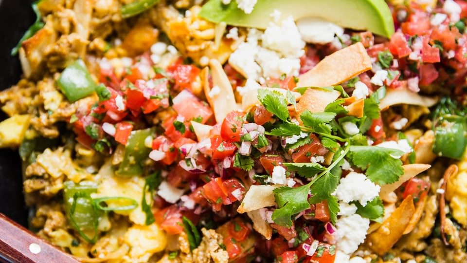 Migas Styled in a skillet with avocado and salsa