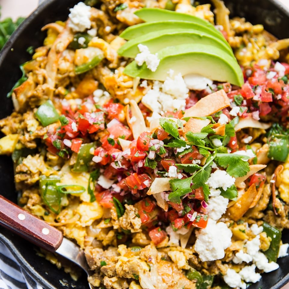 Migas Styled in a skillet with avocado and salsa