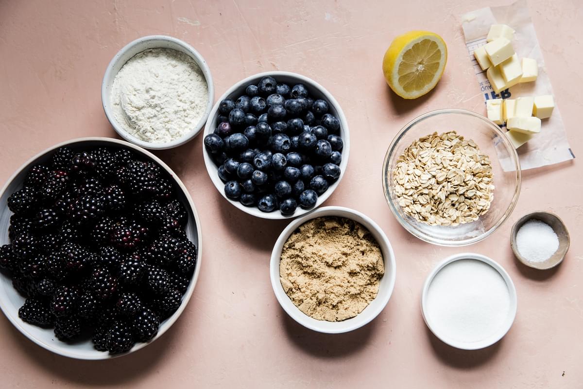 ingredients for easy mixed berry crisp divided in small bowls