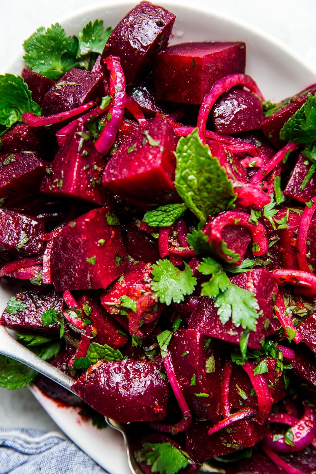 moroccan beet salad on a white platter with fresh herbs