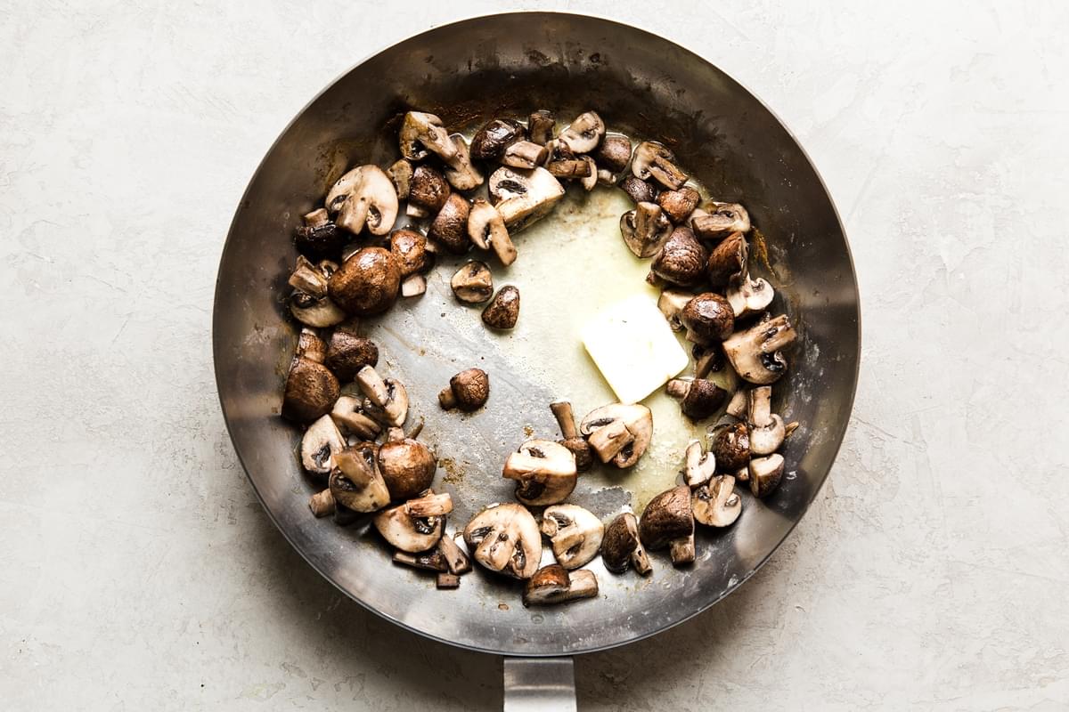 quartered mushrooms in a skillet with butter