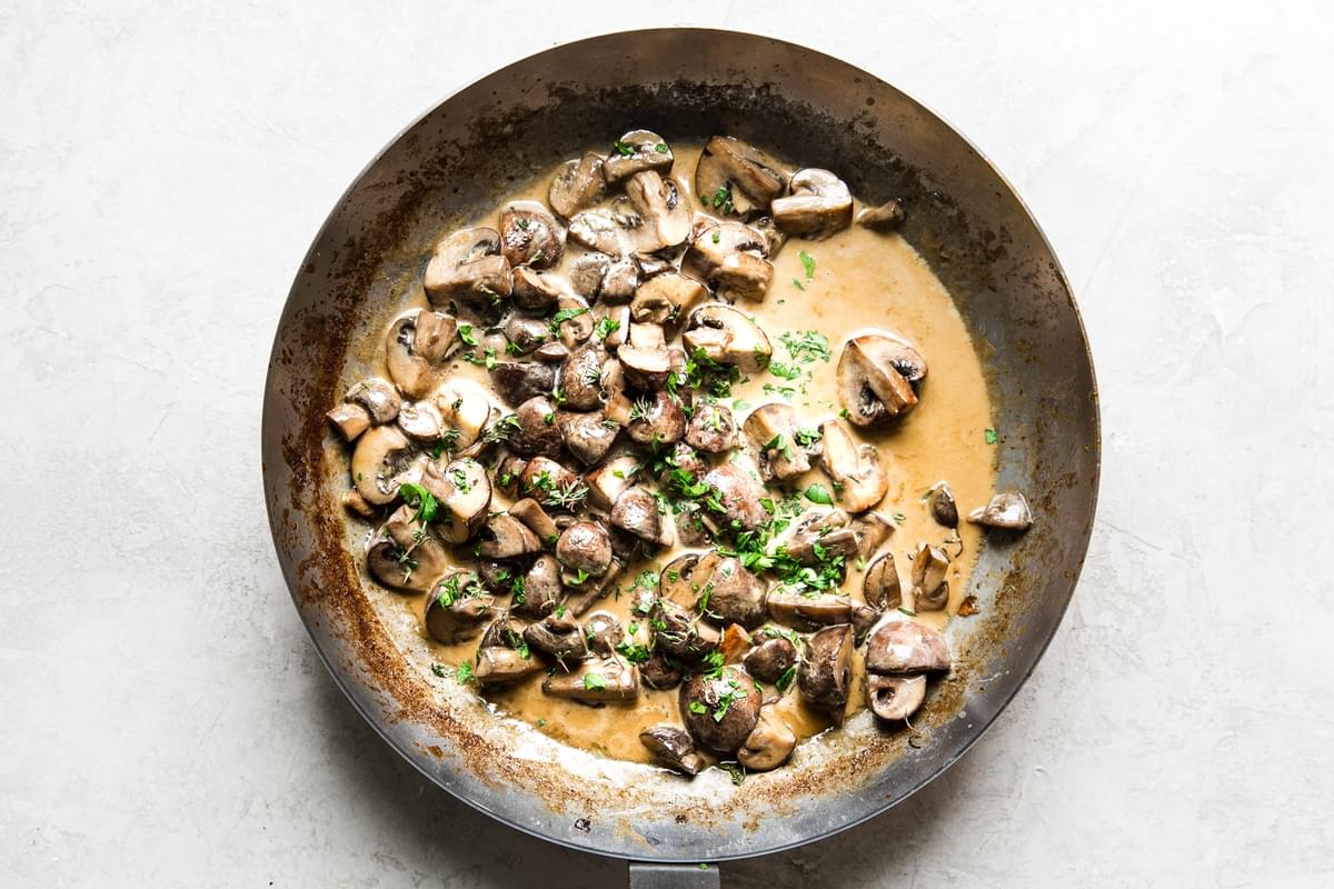 sautéed mushrooms in a skillet with cream, thyme, soy sauce, and butter