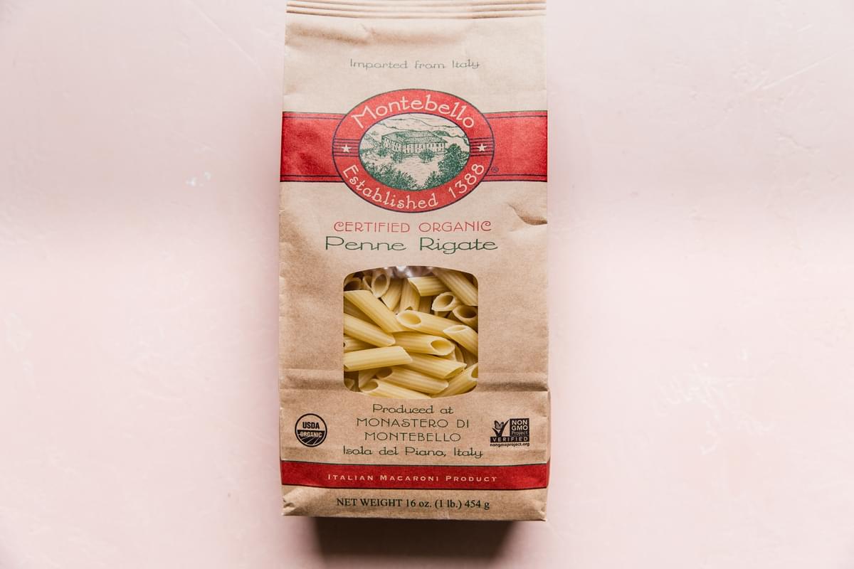 dried pasta in a bag on light pink surface