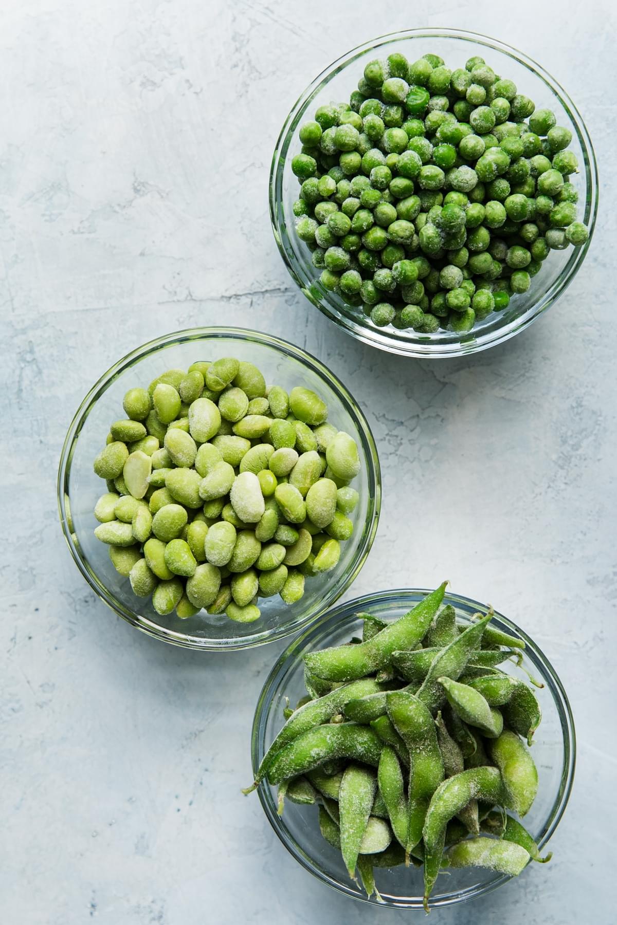 frozen peas, frozen soy beans, frozen edamame in small bowls