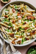 Pasta With Peas Pancetta And Goat Cheese in a bowl with serving spoon