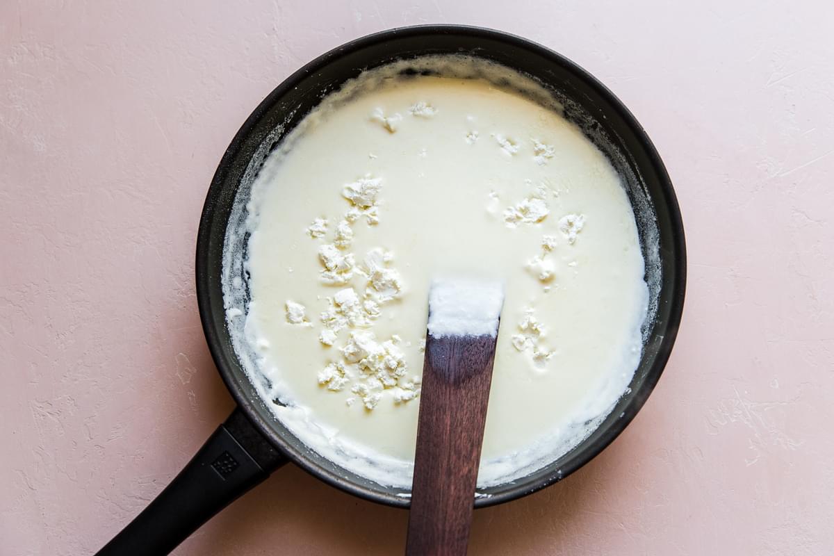 Adding goat cheese to cream sauce in a pan