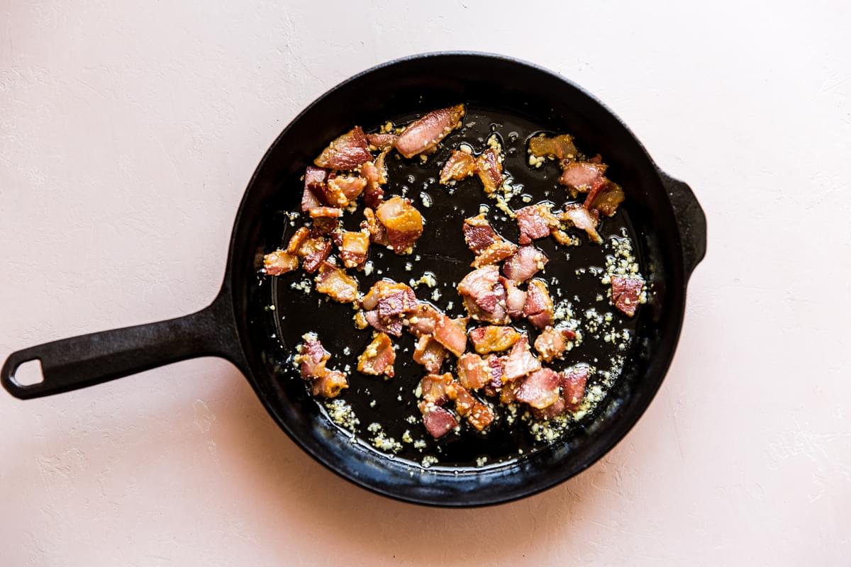 Pancetta frying in a pan with garlic