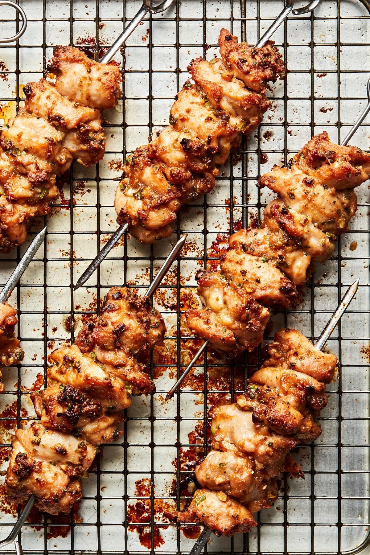 Peanut Sauce Marinated Chicken Skewers on a cooling rack on top of a baking sheet
