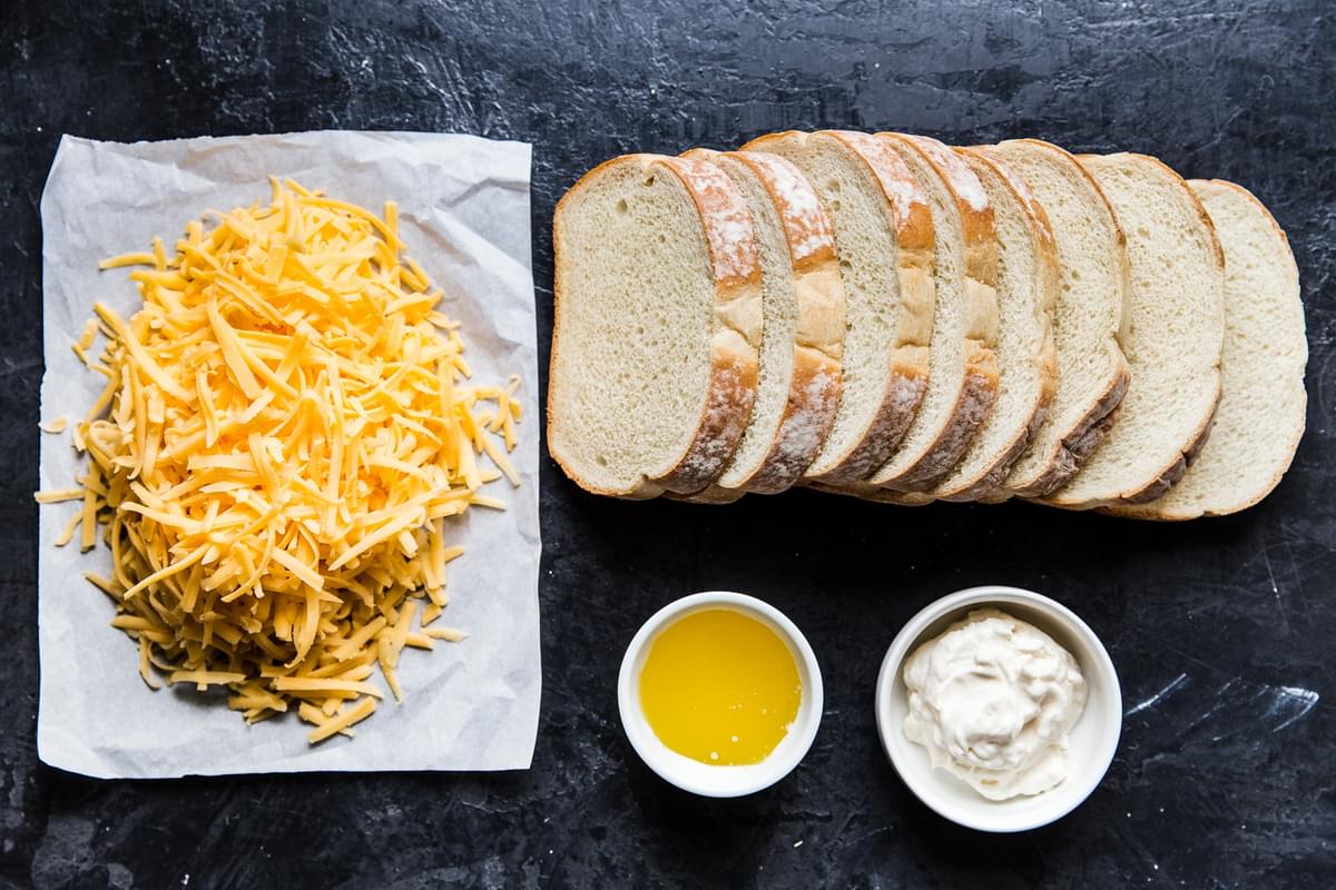 ingredients for perfect grilled cheese sandwich, shredded cheddar, butter, mayonnaise, thick white bread