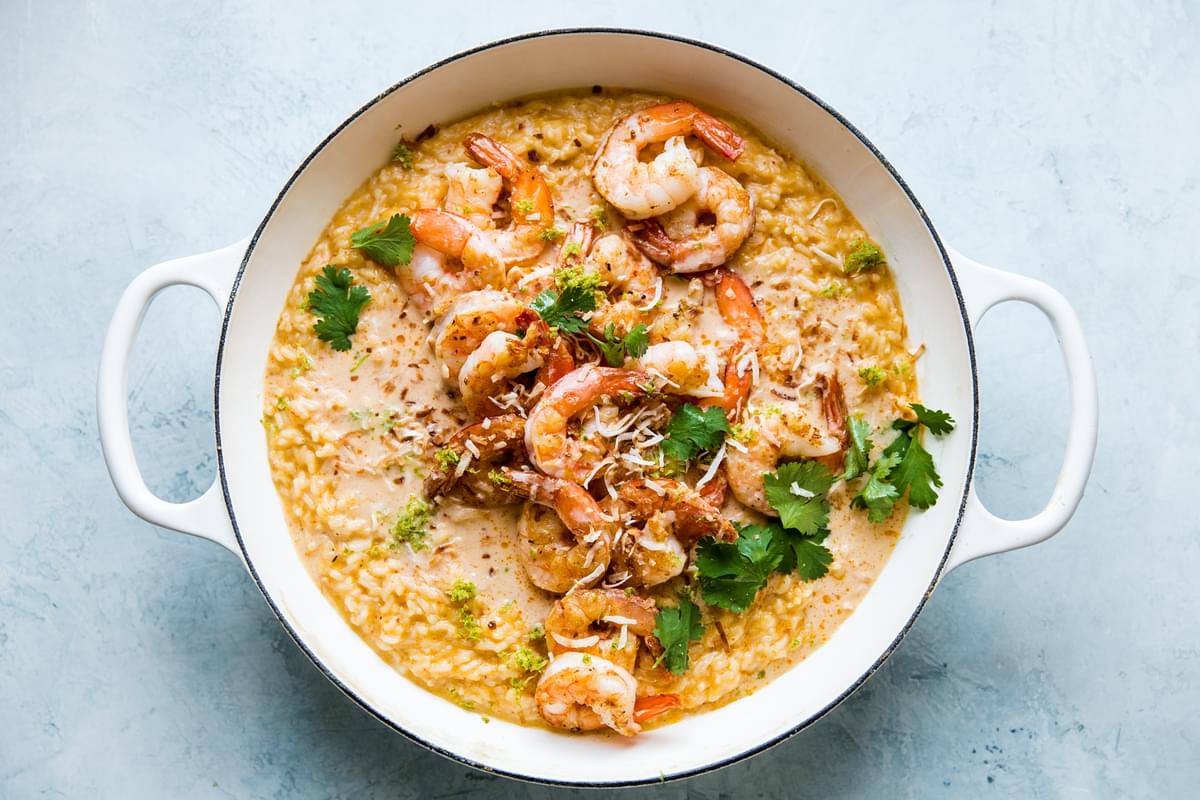homemade red curry risotto in a skillet with crispy shrimp, fresh cilantro and lime zest