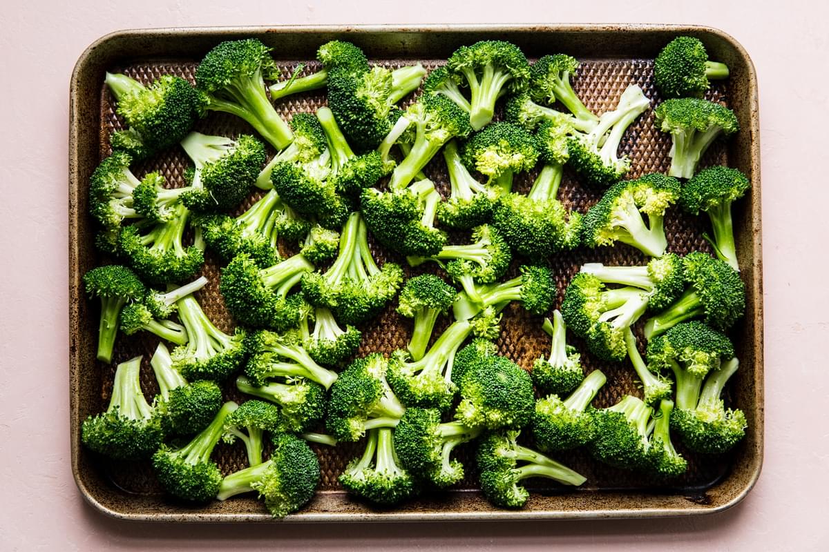 sheet pan of raw broccoli with olive oil and salt