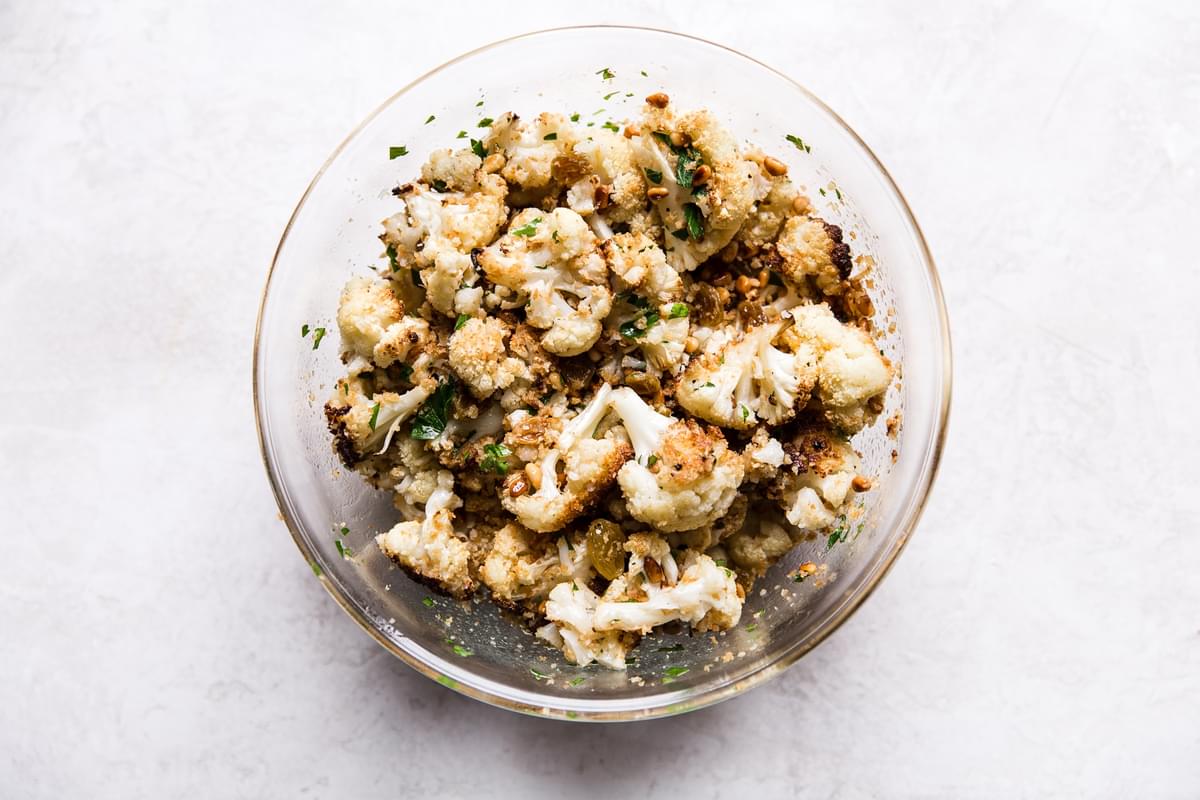 Roasted cauliflower with toasted panko and golden raisins tossed together in a bowl