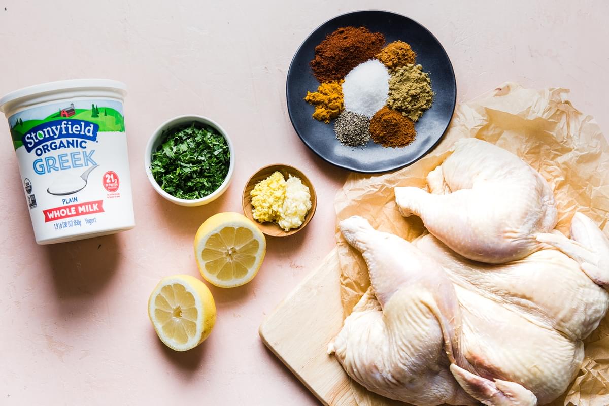 whole raw chicken with spices and fresh herbs and yogurt for tandoori chicken