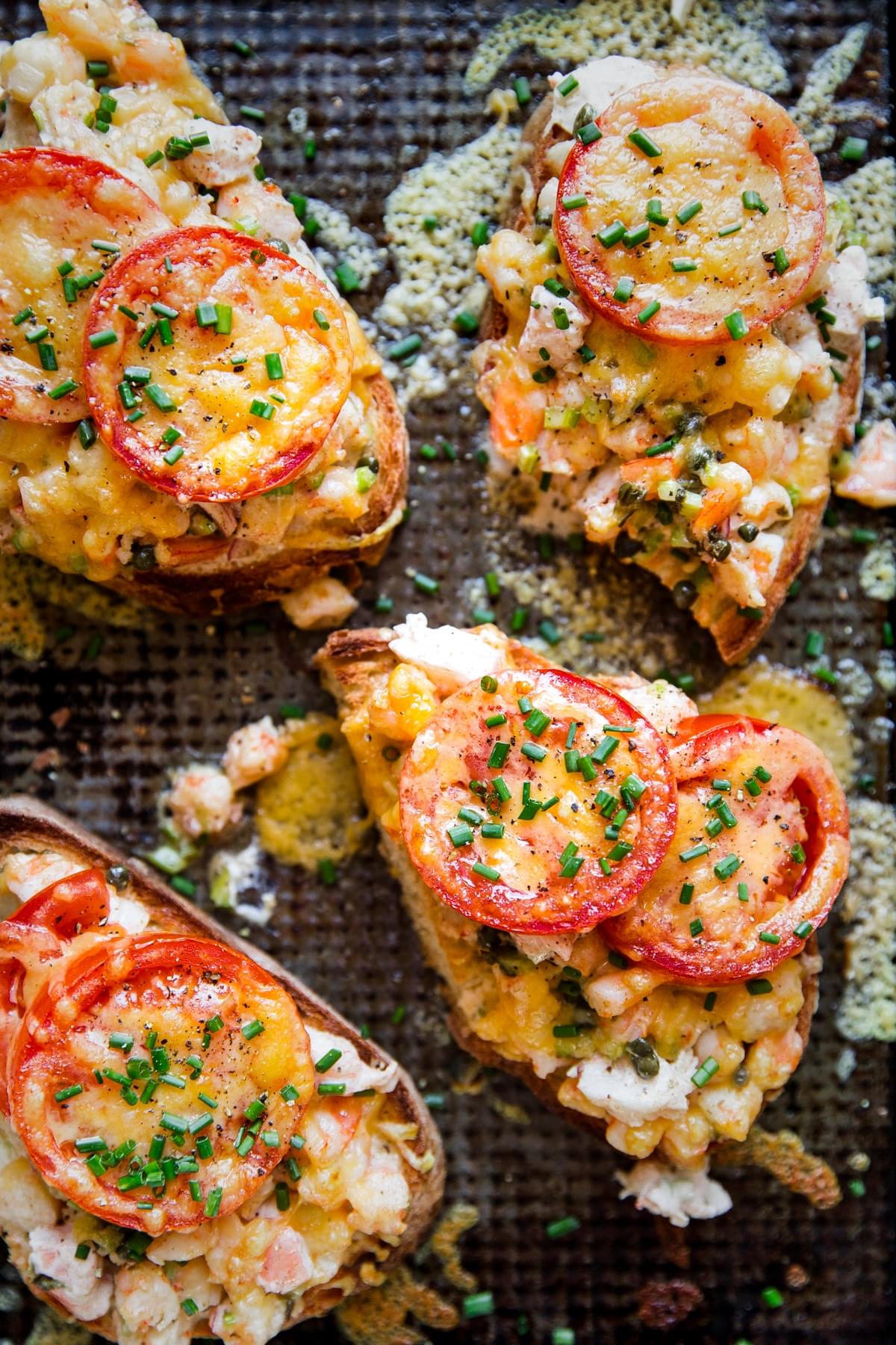 four shrimp melts on a sheet pan topped with fresh chives