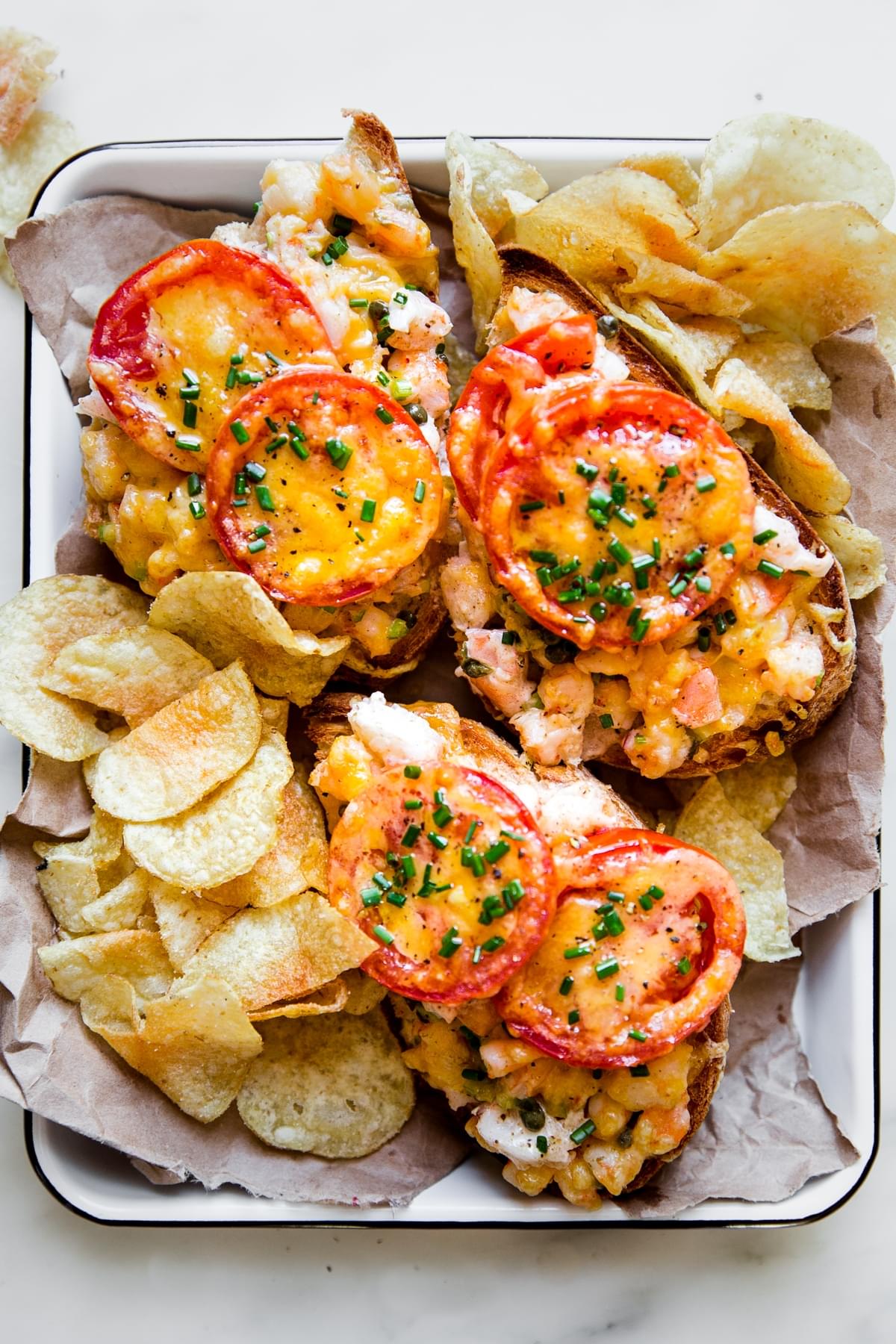 shrimp melts on a parchment lined tray surrounded by potato chips