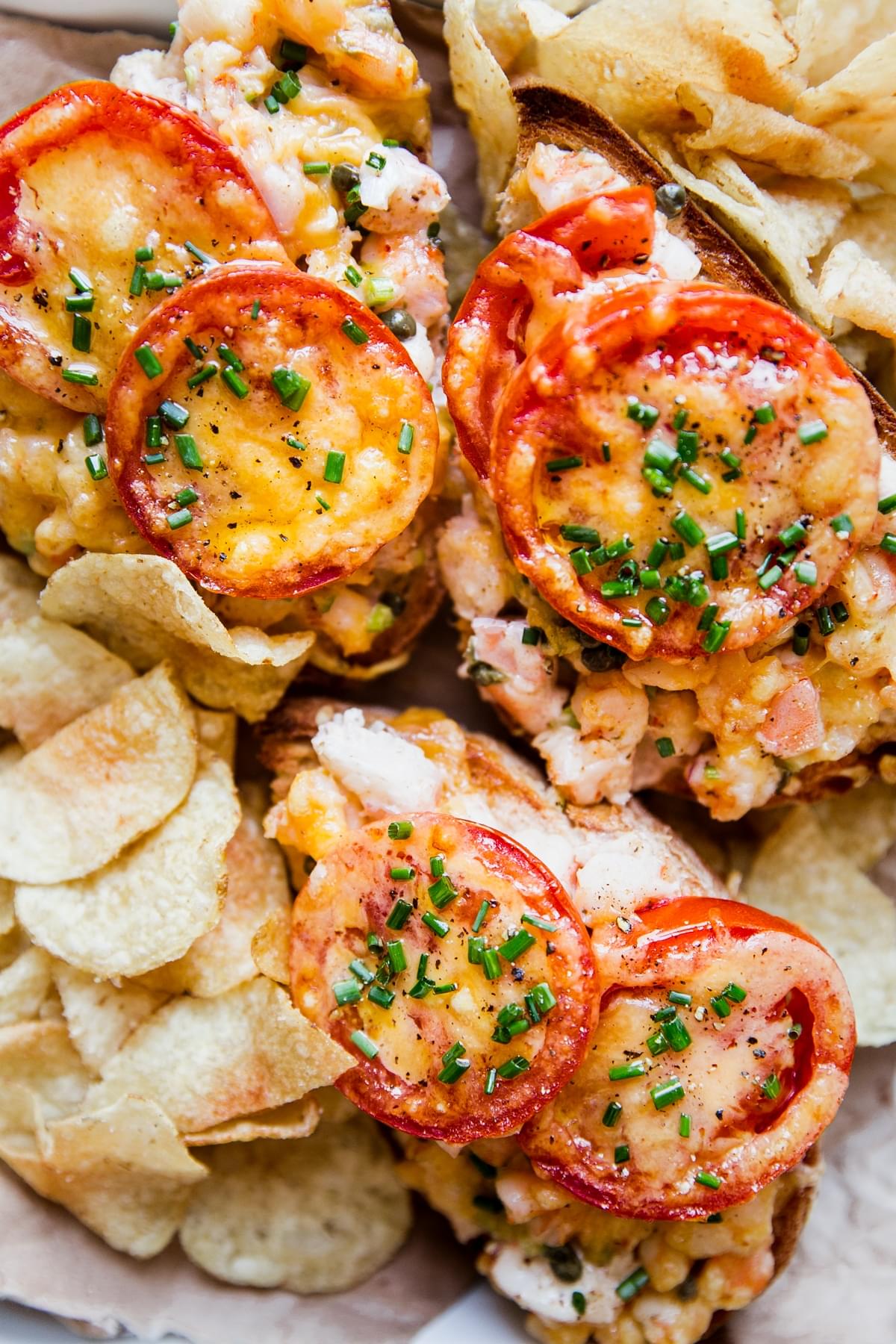 three open faced shrimp melts surrounded by potato chips