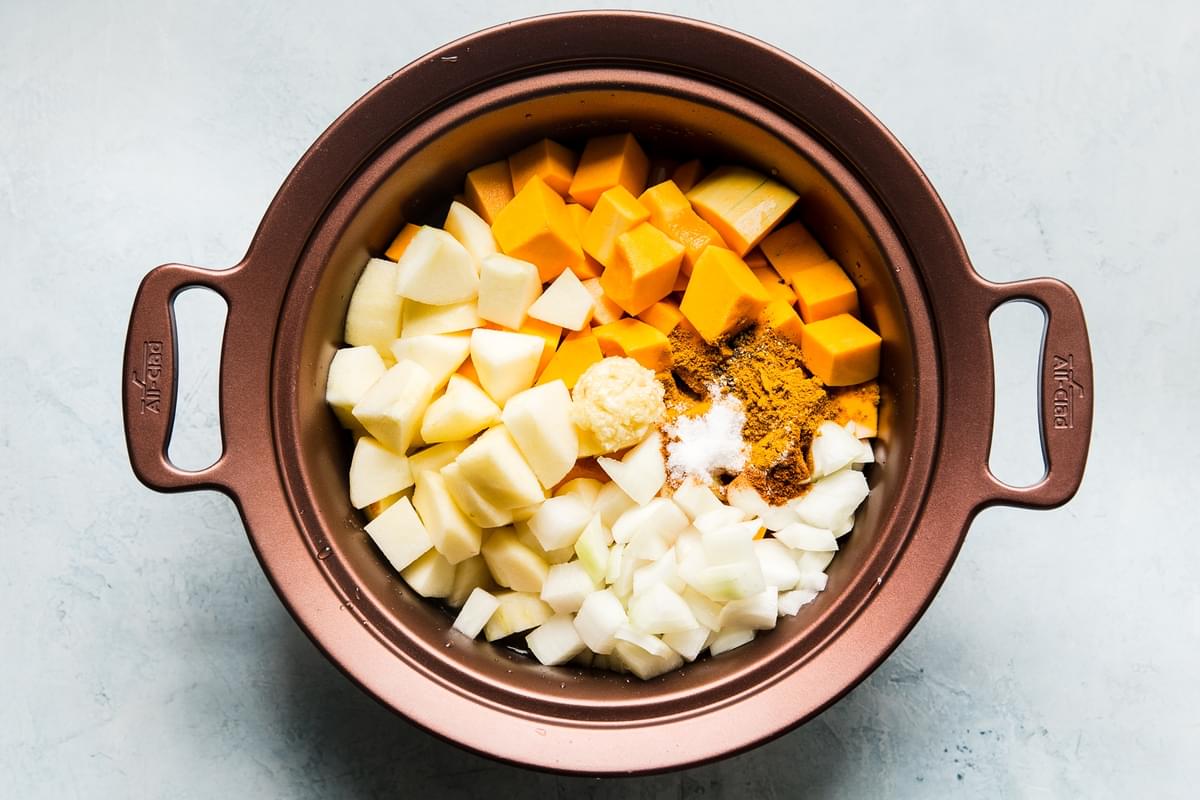 ingredients for slow-cooker butternut squash soup with apples cut up and in a slow-cooker