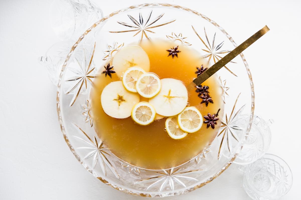 spiced bourbon punch in a crystal punch bowl with a ladle