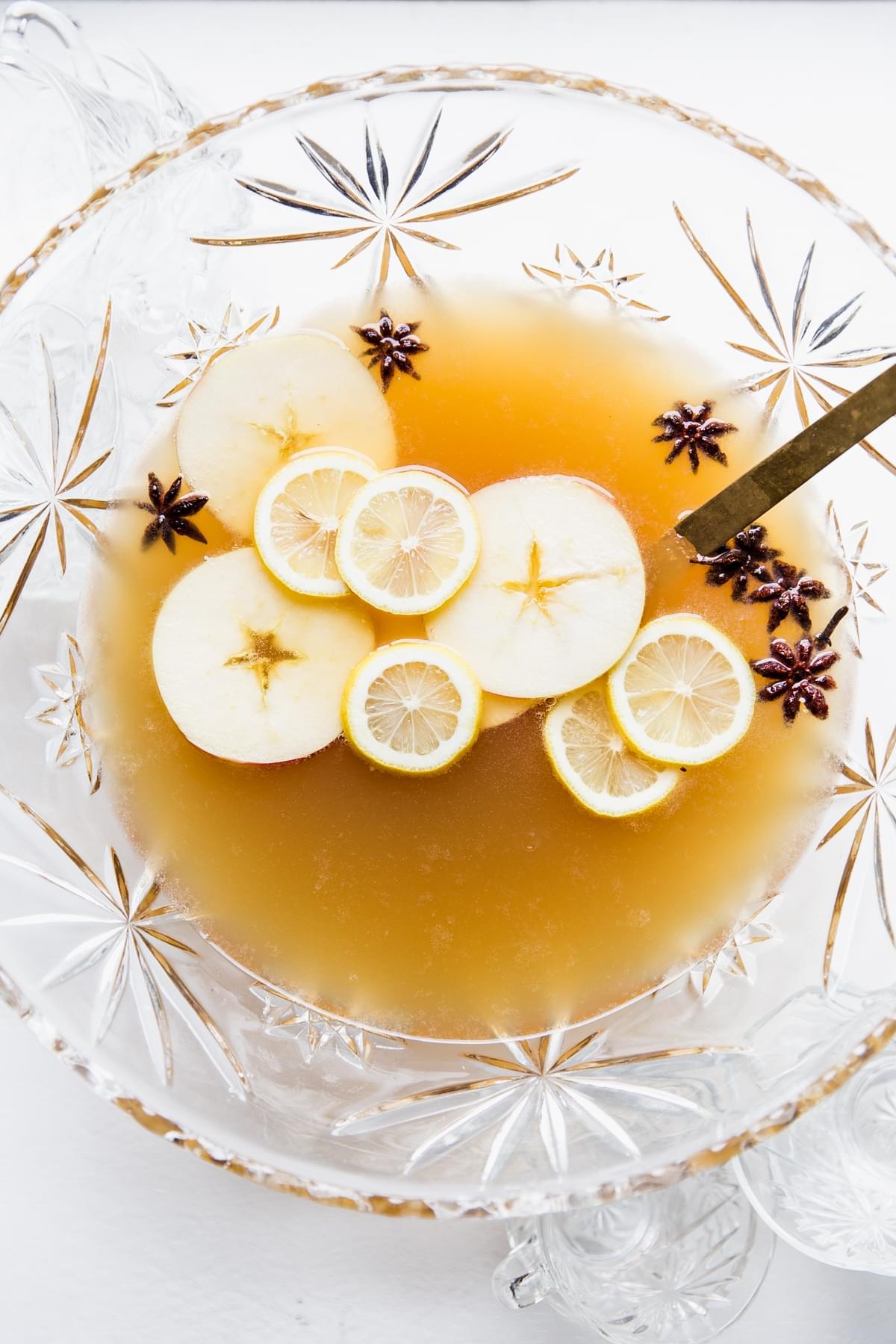 punch bowl topped with apple slices, lemon slices and star anise